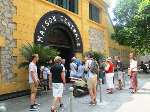 Tourists standing at the gate of Hoa Lo Prison